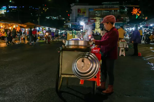Woman selling sweet Sticky Rice from a Street Food Cart at the Night Market in Dalat, Vietnam