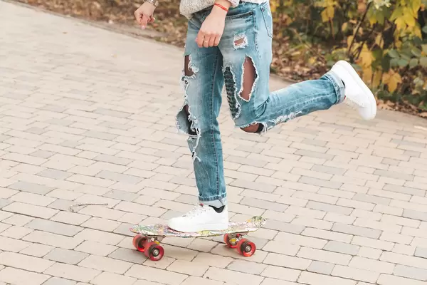 Woman skateboarding at autumn park