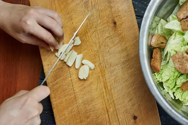 Woman slicing garlic on the cutting board