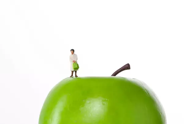 Woman standing on a green apple