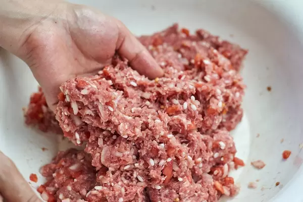 Woman stirring minced meat with rice