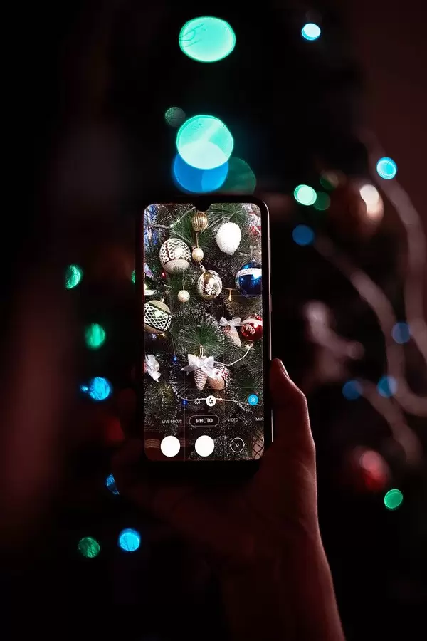 Woman taking picture of Christmas tree decorated