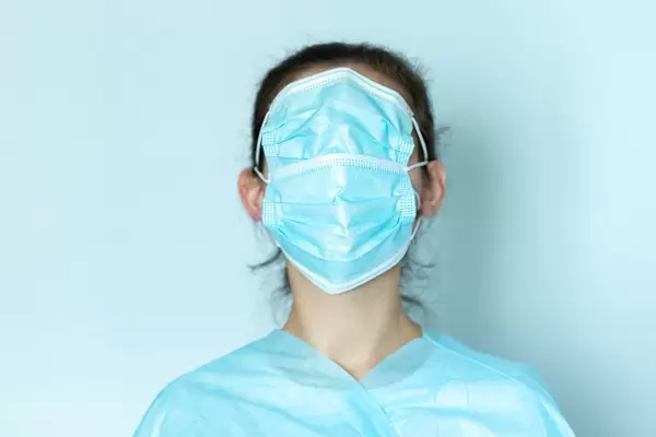Woman wearing a face mask over his eyes, concept fake news, blue background