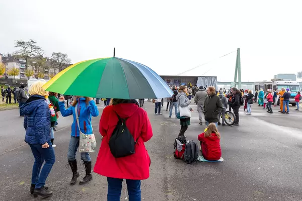 Woman with rainbow umbrella as symbol of peace at rally against anti-Covid measures in Cologne
