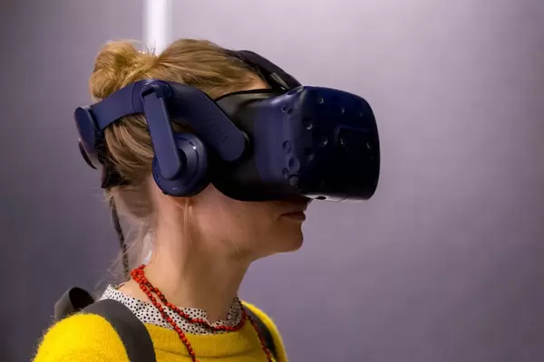 Woman with yellow sweater testing the HTC Vive VR glasses on the Photokina in Cologne