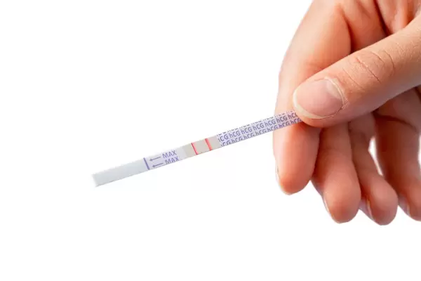 Woman's hand and positive pregnancy test