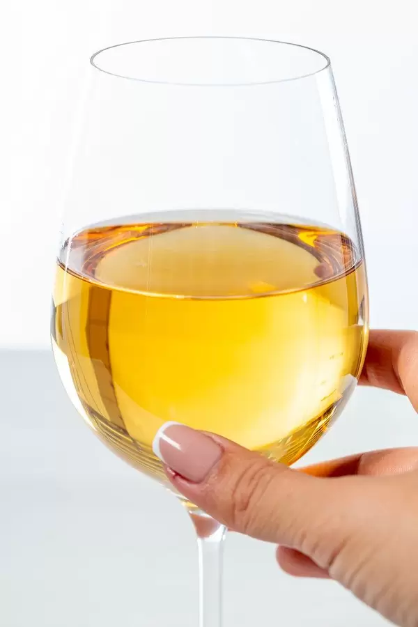 Woman's hand holding a glass of white wine, close-up (Flip 2019)