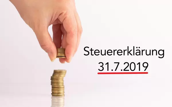 Womans hand picking up coins with Steuererklärung date