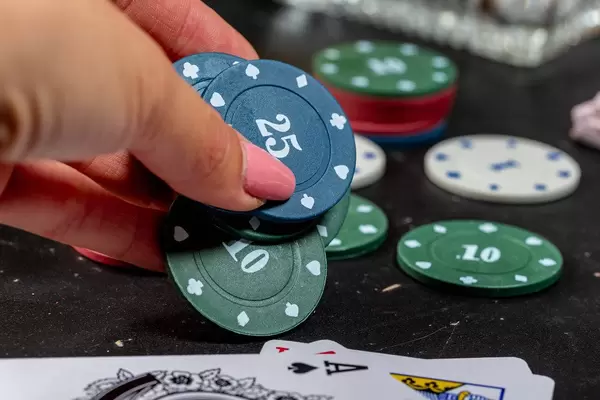 Woman's hand puts on the table chips. The concept of rate increase