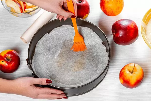 Women grease a baking sheet with butter using a pastry brush (Flip 2019)