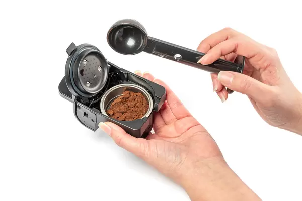 Women hands holding portafilter with ground coffee