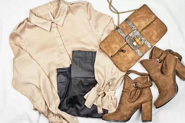 Women's clothing set - skirt, boots, shirt, leather bag on light background