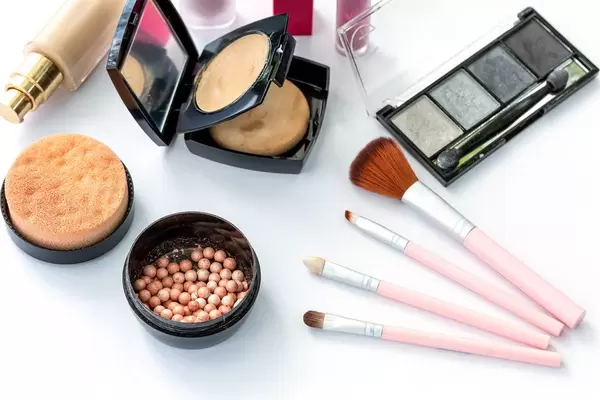 Women's face cosmetics and pink brushes