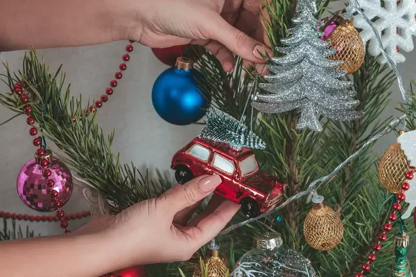 Women's hands hang a toy car on the Christmas tree (Flip 2019)