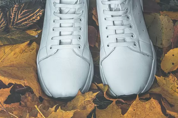 Women's white sneakers on yellow dry leaves (Flip 2019)