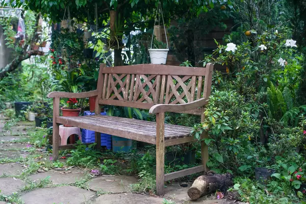 Wooden Bench in a Garden with Flowers and Plants around it
