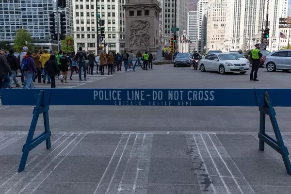 Wooden blue barrier saying "Police line - do not cross. Chicago Police Dept"