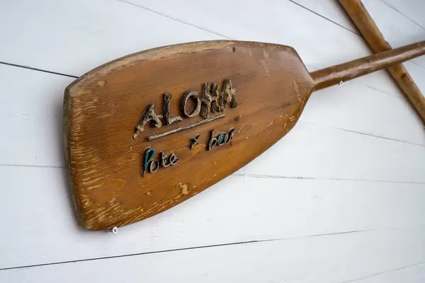 Wooden Boat Paddles attached to a Wall with Aloha Poke & Beer Restaurant Name in Ho Chi Minh City, Vietnam