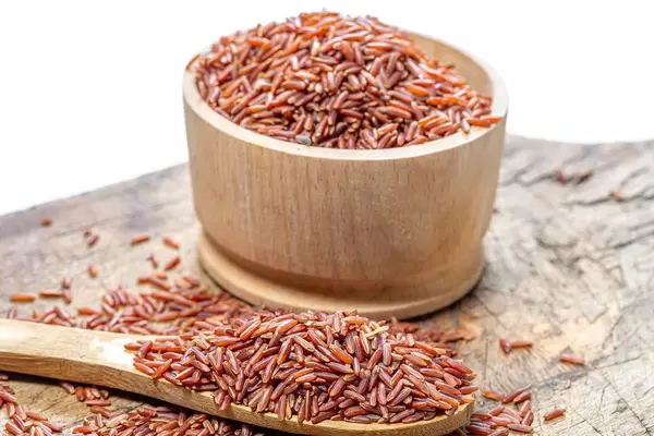 Wooden bowl and spoon with raw brown rice. Healthy diet (Flip 2019)