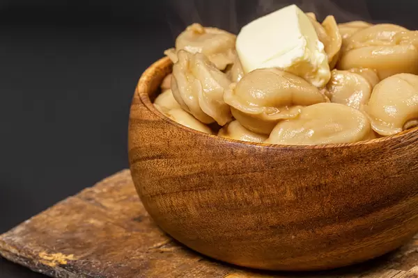 Wooden bowl with dumplings and butter
