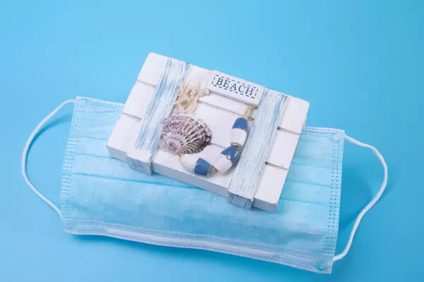Wooden box with medical face mask on blue backgorund