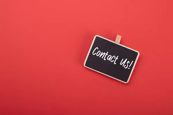 Wooden clip with Contact Us! text on red background