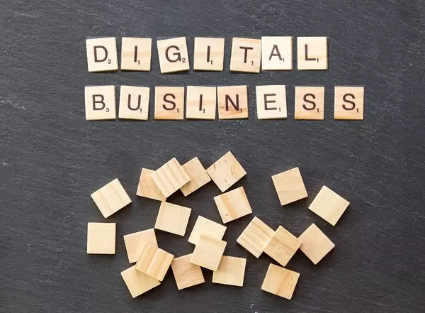 Wooden cubes on a stone surface show "Digital Business"
