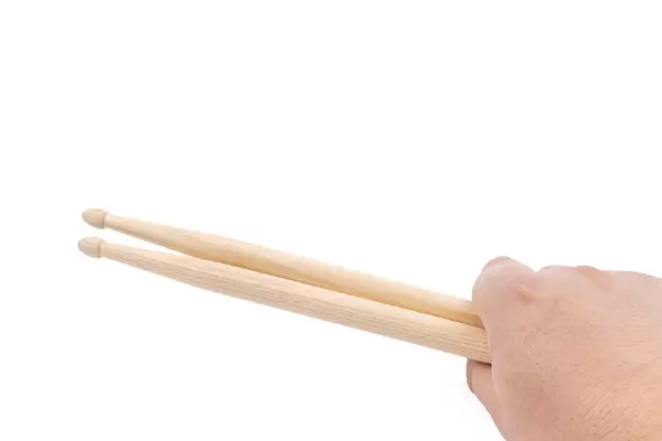 Wooden Drumsticks in the hand above white background with copy space