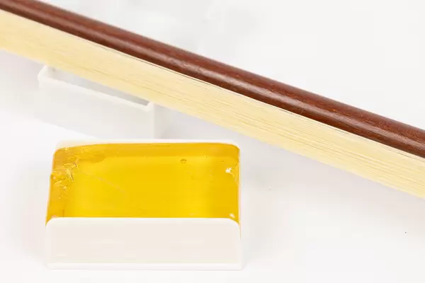 Wooden Fiddle Bow with Rosin above white background