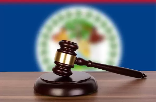 Wooden gavel and flag of Belize