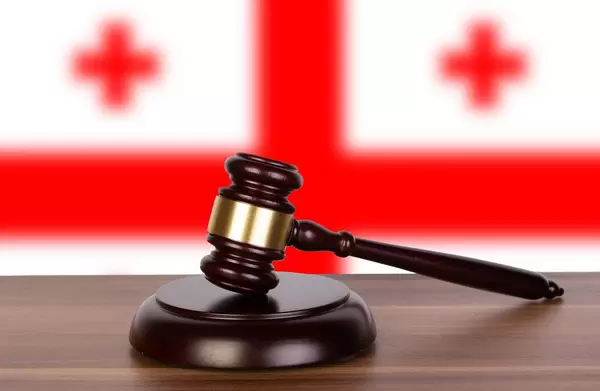 Wooden gavel and flag of Georgia