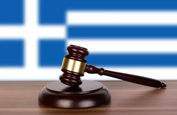 Wooden gavel and flag of Greece