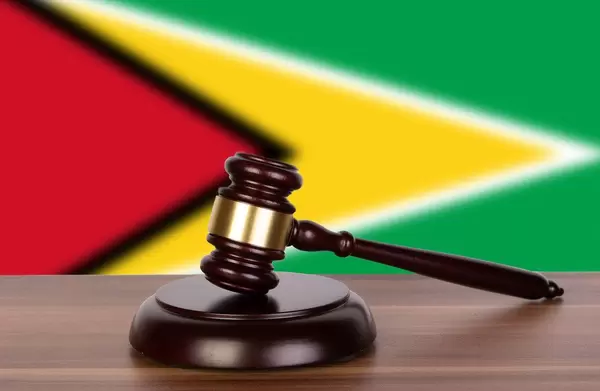 Wooden gavel and flag of Guyana