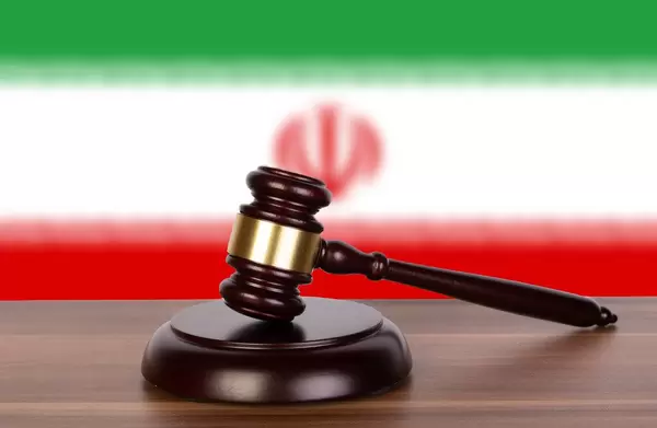 Wooden gavel and flag of Iran