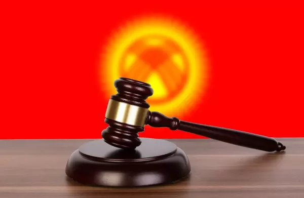 Wooden gavel and flag of Kyrgyzstan