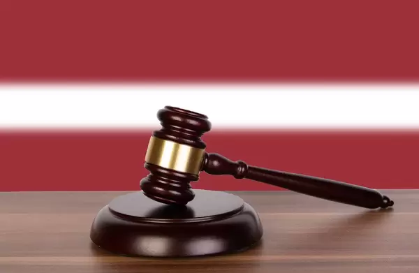 Wooden gavel and flag of Latvia