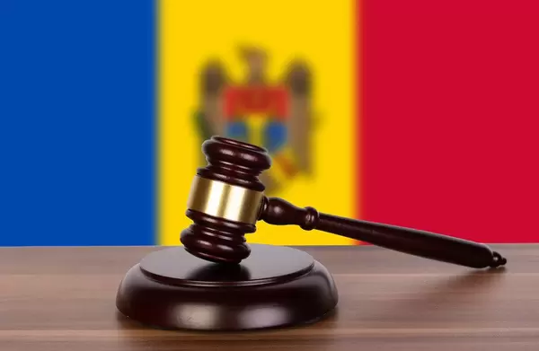 Wooden gavel and flag of Moldova