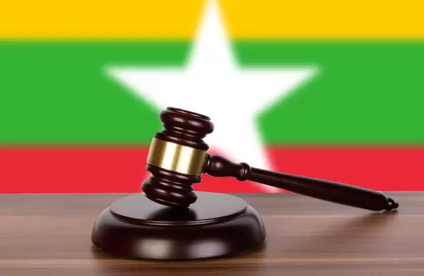 Wooden gavel and flag of Myanmar