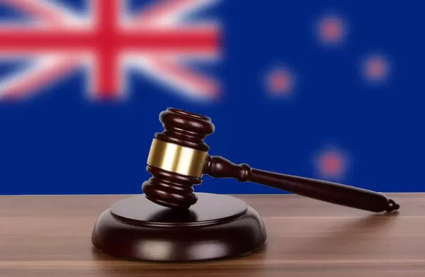 Wooden gavel and flag of New Zealand