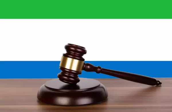 Wooden gavel and flag of Sierra Leone