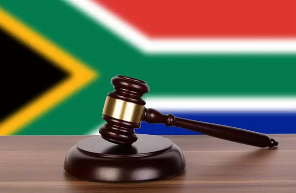Wooden gavel and flag of South Africa