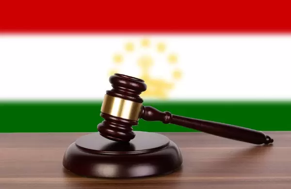 Wooden gavel and flag of Tajikistan
