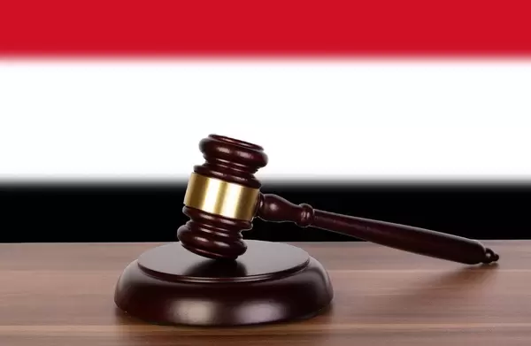 Wooden gavel and flag of Yemen