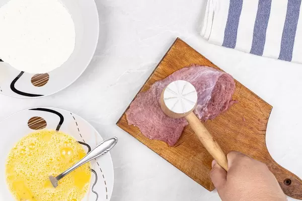 Wooden hammer and preparing Pork Meat with mixed eggs and flour
