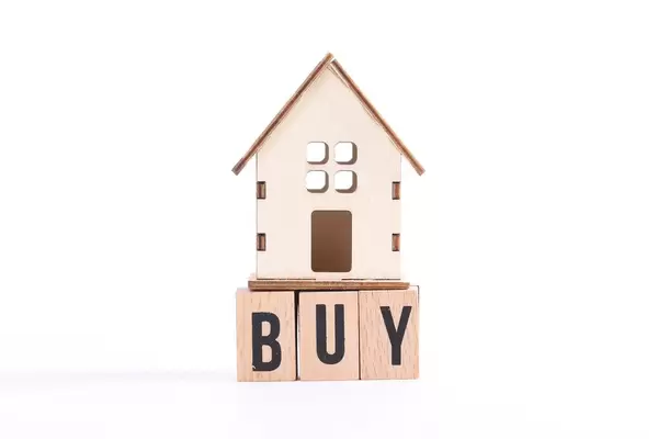 Wooden house and the word Buy on white background