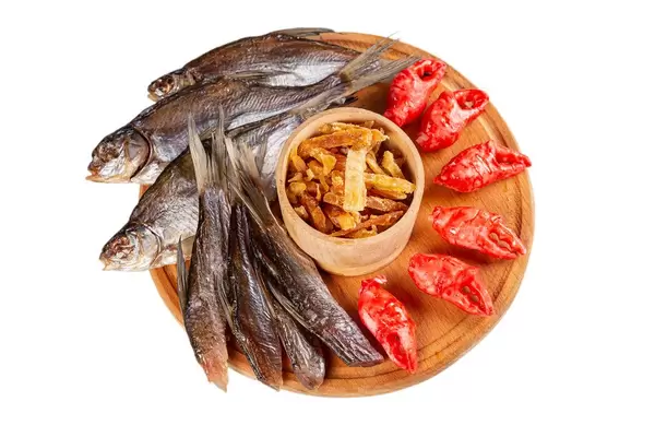 Wooden round board with a set of beer snacks on a white background
