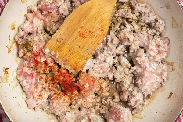 Wooden spatula in minced meat with spices