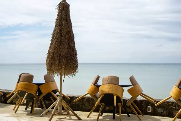 Wooden Tables and Chairs with Bamboo Leaves Sun Umbrella at a Beach Bar on Phu Quoc Island, Vietnam