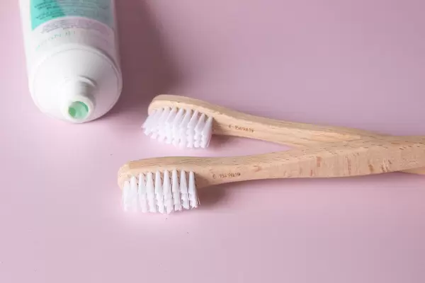 Wooden toothbrushes on pink background