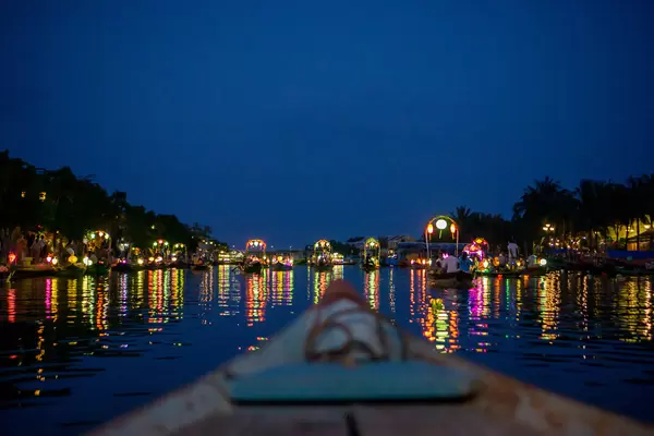 Wooden Tourist Boats with Bright Colorful Lanterns on Thu Bon River with Light reflecting in the Water in Hoi An, Vietnam
